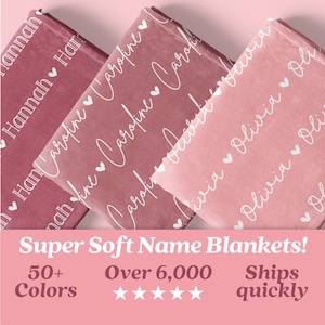 May include: Three personalized blankets with different names, "Hannah", "Caroline", and "Olivia", printed in white script with hearts on a pink and rose colored background. The blankets are folded and stacked on top of each other. The text "Super Soft Name Blankets!" is printed in white on a pink background below the blankets. The text "50+ Colors" is printed in white on a pink background below the text "Super Soft Name Blankets!". Five white stars are printed below the text "Over 6,000" which is printed in white on a pink background. The text "Ships quickly" is printed in white on a pink background.