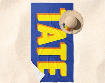 May include: A blue beach towel with the word "TATE" written in yellow letters with orange outlines.