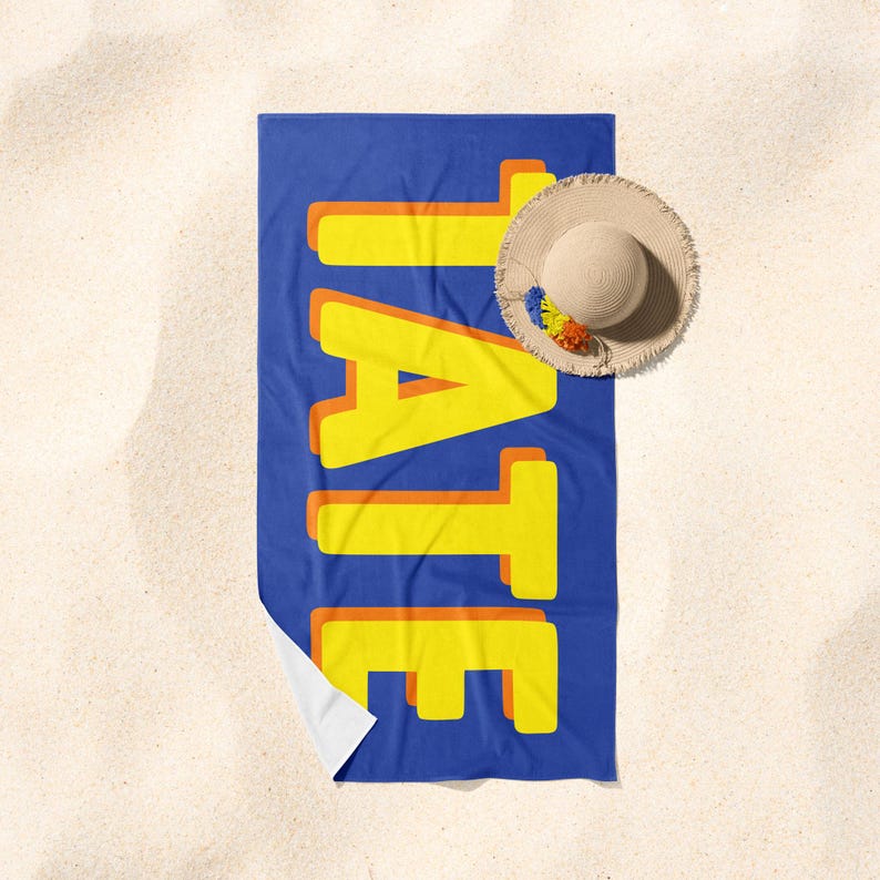 May include: A blue beach towel with the word "TATE" written in yellow letters with orange outlines.
