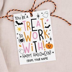 May include: A rectangular white gift tag with black, orange, and pink text reading "YOU'RE A TREAT TO WORK WITH! HAPPY HALLOWEEN! FROM: YOUR NAME". The tag features illustrations of bats, a spider, a pumpkin, and ghosts, tied with orange and black twine.
