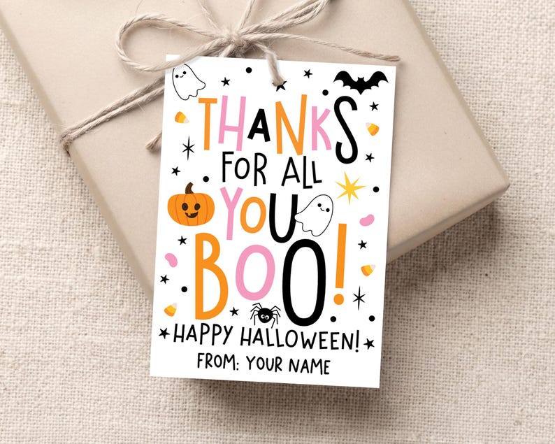 White Halloween gift tag tied with twine to a beige wrapped present, with pink, orange, and black “Thanks for All You Boo! Happy Halloween!” lettering and small spooky icons.