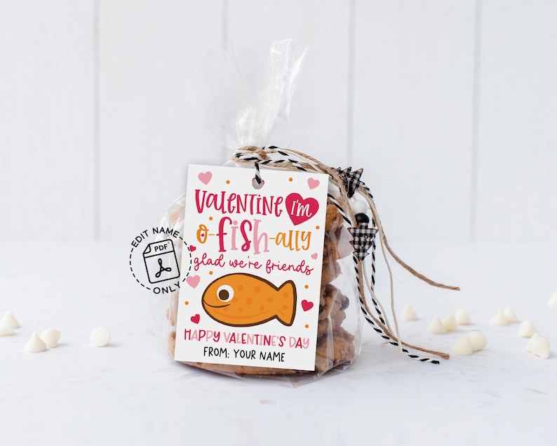 Fun fish-themed valentine tag printable displaying the words “You are o-fish-ally awesome” above a pink polka dot fish illustration, with “Happy Valentine’s Day” and name line below, meant to be printed, cut, and attached to classroom gift bags or goodie sacks.