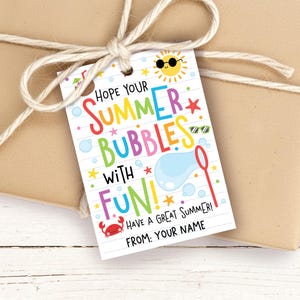 May include: A gift tag with the text "HOPE YOUR SUMMER BUBBLES WITH FUN!" in colorful letters. The tag features illustrations of a sun, stars, bubbles, and a crab. The tag is tied to a brown package with twine.