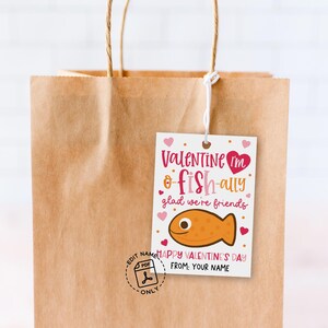 Valentine favor tag printable arranged on kraft paper bags, each card showing a pink cartoon fish, playful red and brown lettering, and scattered heart graphics, created for parents or teachers to print, cut, and clip to small treats for kids and classmates.