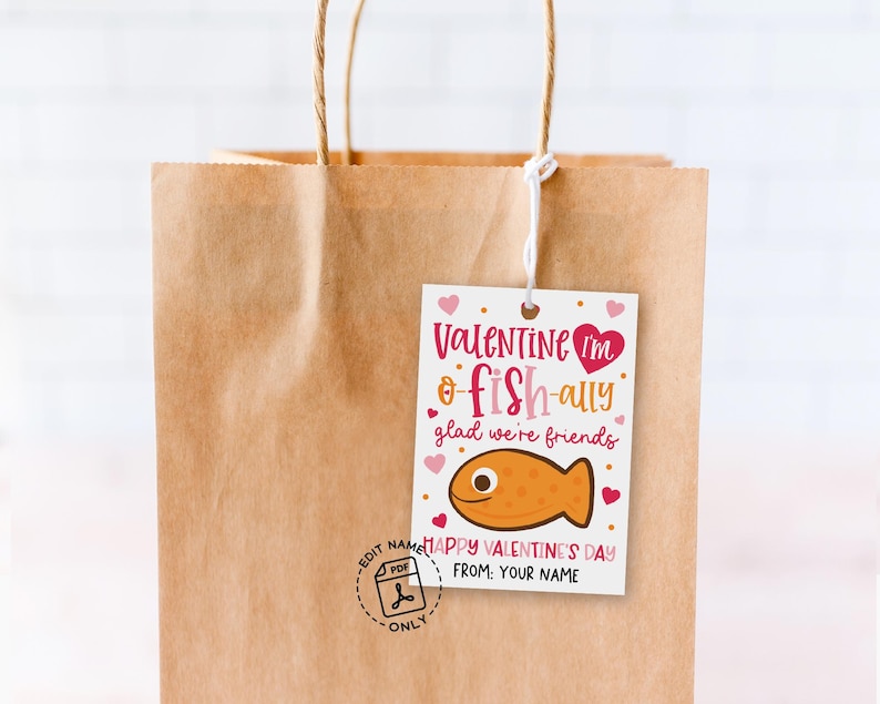 Valentine favor tag printable arranged on kraft paper bags, each card showing a pink cartoon fish, playful red and brown lettering, and scattered heart graphics, created for parents or teachers to print, cut, and clip to small treats for kids and classmates.