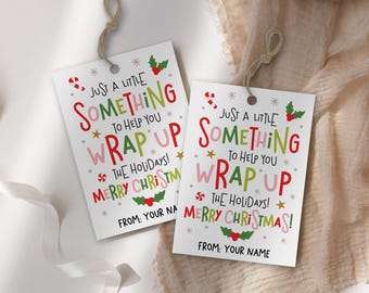 May include: Two white gift tags with the text "Just a little something to help you wrap up the holidays! Merry Christmas!" in red, green, and pink. Each tag has a hole at the top with twine.