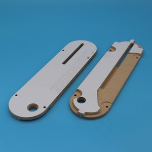 May include: Two white and brown router templates for woodworking. The larger template has the text "ZEROSERT" printed on it.