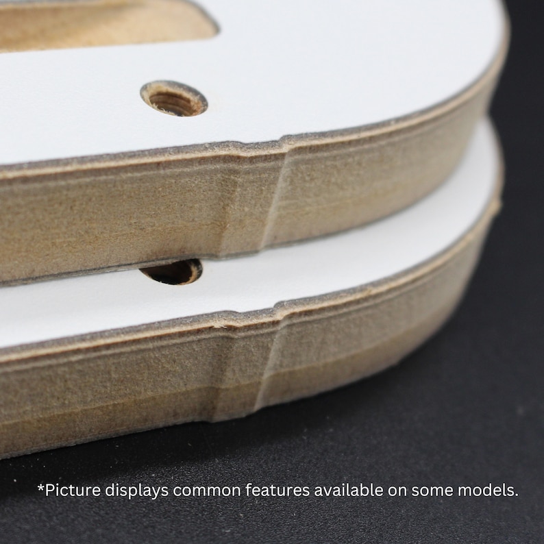 May include: Close-up of two wooden pieces with white tops and visible screw holes. The edges are a natural wood color, and the white surfaces are smooth. The text at the bottom reads, "*Picture displays common features available on some models."