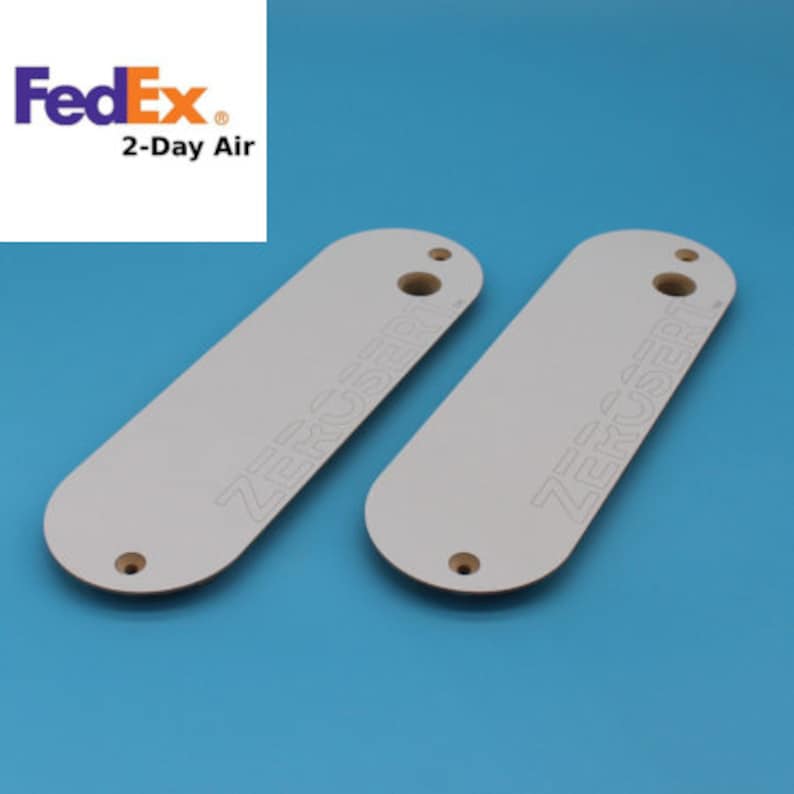 Peut inclure: Deux blancs en bois de forme ovale de couleur blanche avec le texte "ZERO USERT" imprim&eacute; dessus. Les blancs ont un trou au centre.