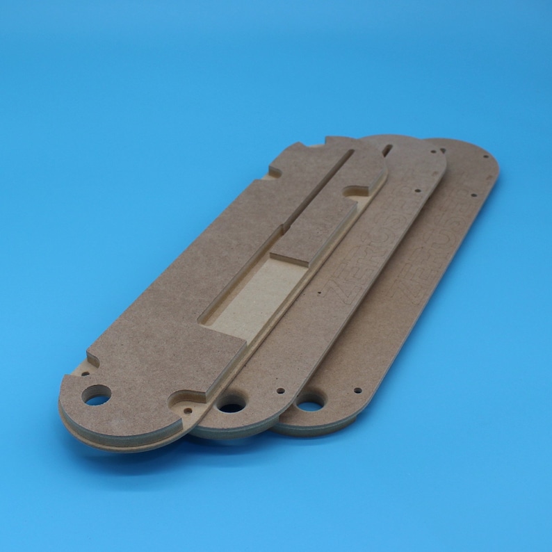 May include: Three unfinished wooden pieces with cutouts and holes. The pieces are stacked on top of each other.