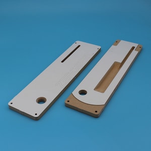 May include: Two white and brown wooden router jigs with the text "ZERO SR" printed on one of the jigs.