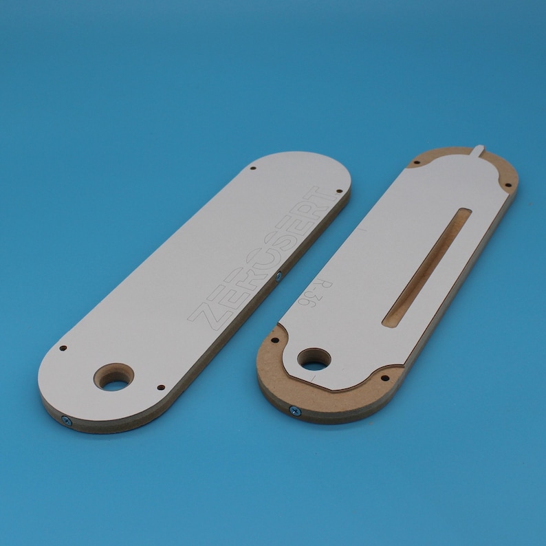 May include: Two white and brown wooden router templates with the text "ZeroClear" printed on one of the templates.