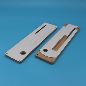 May include: Two white and brown wooden router jigs with cutouts and holes. The larger jig has the text "ZeroInsert" printed on it.