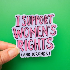 May include: A sticker with the text "I support women's rights (and wrongs)" in pink lettering on a light purple background.
