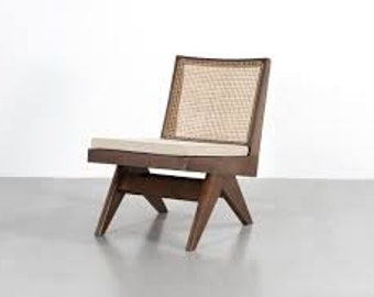 May include: A mid-century modern chair with a dark wood frame and a woven cane back. The chair has a rectangular seat cushion and angled legs. The chair's dimensions are approximately 28 inches high, 24 inches wide, and 26 inches deep.