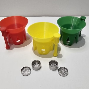 May include: Three 3D printed funnels in red, yellow, and green with a small handle on the side. Four small metal mesh screens are also included.