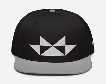May include: A black and gray baseball cap with a white geometric design on the front. The cap has a flat brim and a curved crown.