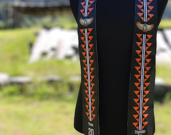 May include: Black graduation stole with orange and white geometric patterns. The stole has a bird graphic and the text "Pomo 20" on one side and "Thunder Fox 23" on the other side.
