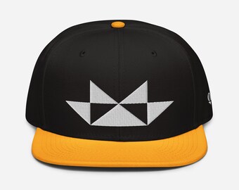 May include: A black and white geometric design on a black and yellow baseball cap.