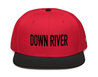 May include: A red and black baseball cap with the text "DOWN RIVER" in black lettering.