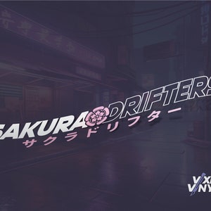 May include: A white and pink graphic design with the text "Sakura Drifters" in a stylized font. The text is in English and Japanese. The design also includes a pink cherry blossom flower.