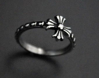 Könnte beinhalten: Ein silberner Ring mit einem Kreuzdesign. Der Ring ist aus Metall und hat ein schlichtes, elegantes Design.