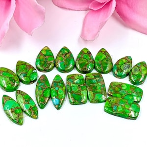 May include: A collection of 14 green and copper turquoise cabochons in various shapes, including teardrop and rectangular. The stones have a mottled pattern and are perfect for jewelry making.