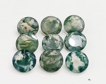 May include: Ten round, faceted green moss agate gemstones. The stones have a mix of green and white patterns.