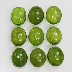 以下が含まれることがあります： 滑らかで磨かれた仕上げの丸い緑色の宝石が9つ。石は3行3列に配置されています。