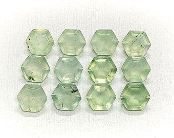 Könnte beinhalten: Zwölf hexagonale grüne Edelsteine mit schwarzen Einschlüssen. Die Edelsteine sind in vier Reihen zu je drei angeordnet.