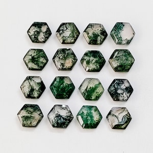 May include: A collection of 16 green moss agate cabochons, each cut into a hexagonal shape. The stones have a natural, organic look with swirls of green and white.