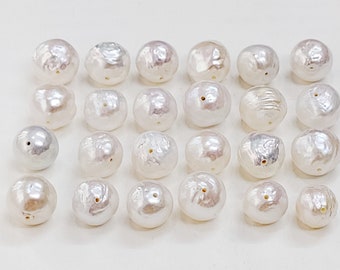 May include: A collection of 27 white baroque pearls with a slight iridescent sheen. The pearls are round and have a smooth surface. They are arranged in a grid pattern on a white background.