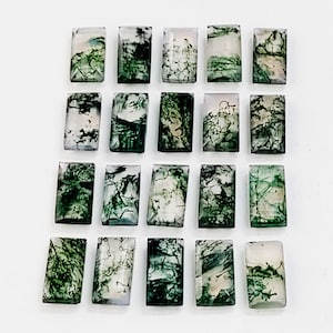 Puede incluir: Veinte cabujones de ágata verde musgo, cada uno con un patrón único de dendritas verdes y blancas. Los cabujones son de forma rectangular y tienen un acabado liso y pulido.