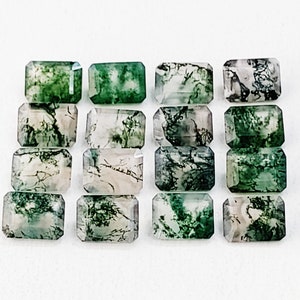 May include: A collection of 16 green and white moss agate gemstones, cut into emerald shapes. The stones have a natural, organic pattern.