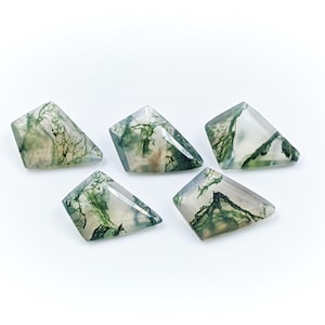 Puede incluir: Cinco cabujones de ágata verde y blanca en forma de cometa. Las piedras tienen una apariencia translúcida con patrones verdes y blancos.