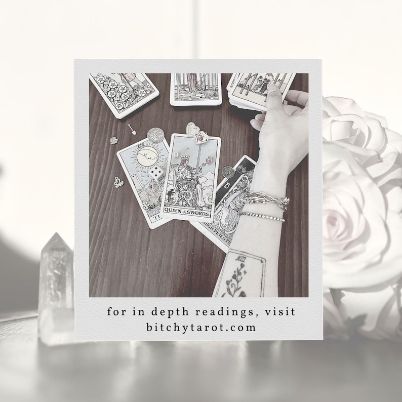 May include: A collection of tarot cards, including the Queen of Swords, arranged on a wooden surface. The image features a hand holding cards, with the text "for in depth readings, visit bitchytarot.com" at the bottom.