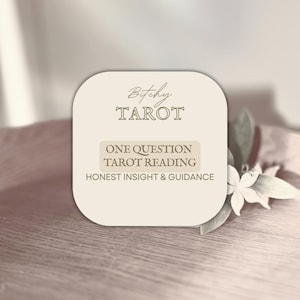 May include: A beige card with rounded corners displays the text "Bitchy Tarot" and "One Question Tarot Reading: Honest Insight & Guidance." The card is set on a wooden surface with a flower and leaves.