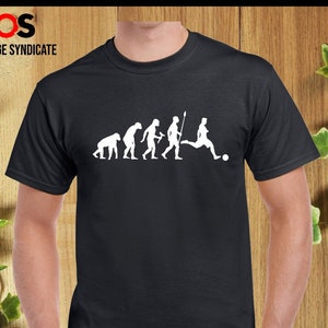 May include: Black t-shirt featuring a white graphic of the evolution of man, culminating in a footballer kicking a ball. The text "ORANGE SYNDICATE" is printed above the graphic.