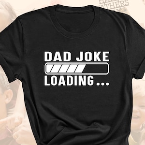 May include: Black t-shirt with white text that reads "Dad Joke Loading..." with a progress bar underneath. The progress bar is almost full.