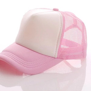 May include: A pink and white trucker hat with a mesh back. The front of the hat is solid pink and the back is a pink mesh.