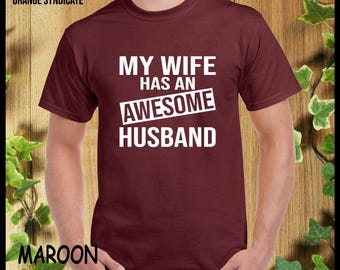 May include: Maroon t-shirt with white text that reads "My wife has an awesome husband".