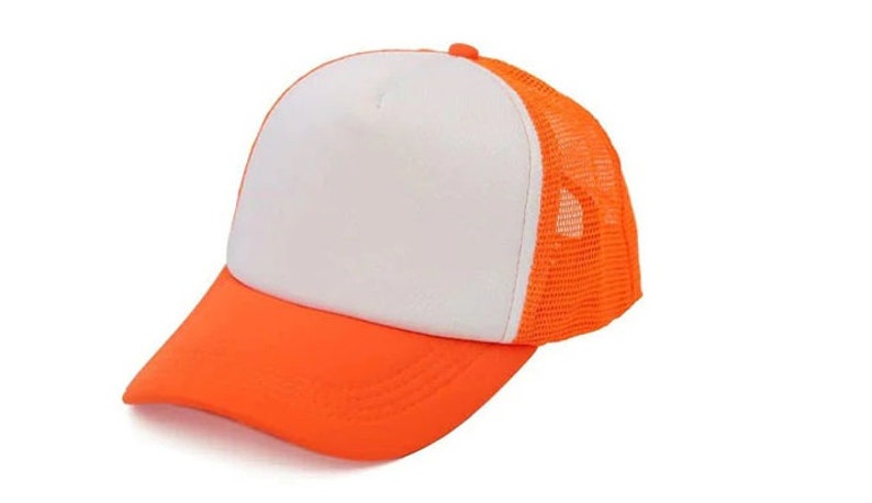 May include: A white and orange trucker hat with a mesh back. The hat has a curved brim and a flat crown.