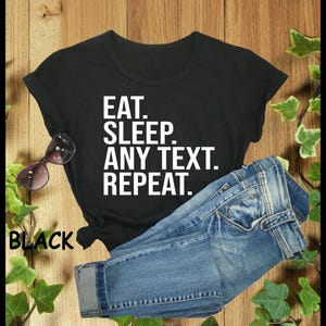 May include: Black t-shirt with white text that reads "Eat. Sleep. Any Text. Repeat."