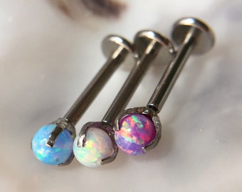Puede incluir: Tres piezas de joyería corporal de plata con piedras preciosas de ópalo. Los colores del ópalo son azul claro, blanco y rosa.