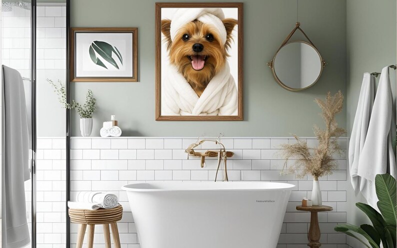May include: A bathroom scene featuring a framed picture of a dog wearing a white robe and towel. The room has a white bathtub, a round mirror, and a wooden stool. The walls are painted a light green color.