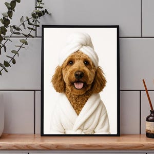 May include: Framed print featuring a golden doodle dog wearing a white spa robe and towel. The dog is smiling with its tongue out. The image is set against a white background.