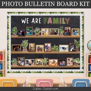 May include: A photo bulletin board kit featuring a black chalkboard background with three horizontal shelves. The text WE ARE FAMILY is displayed at the top. The shelves hold various framed photographs of people and potted plant illustrations.