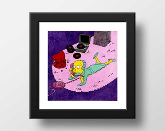 May include: A framed square art print featuring a yellow cartoon character in a light green robe lying on a pink rug, talking on a red rotary phone. Nearby are a record player, vinyl records, and a heart-shaped box of chocolates.