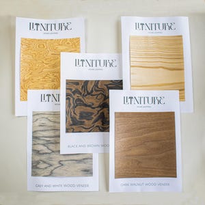 Peut inclure: Cinq échantillons de placage de bois avec le texte "LINITURE HOME LIGHTING" imprimé sur chacun. Les échantillons sont étiquetés "Grey and White Wood Veneer", "Dark Walnut Wood Veneer", "Black and Brown Wood Veneer", et deux échantillons avec uniquement le texte "LINITURE HOME LIGHTING".