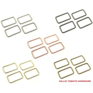 May include: Four sets of four rectangular metal rings in gold, silver, rose gold, and bronze. Each ring is about 1 inch wide and 1.5 inches long.  The rings are arranged in rows of four, with each row a different color.  The text "SALLIE TOMATO HARDWARE" is at the bottom of the image.